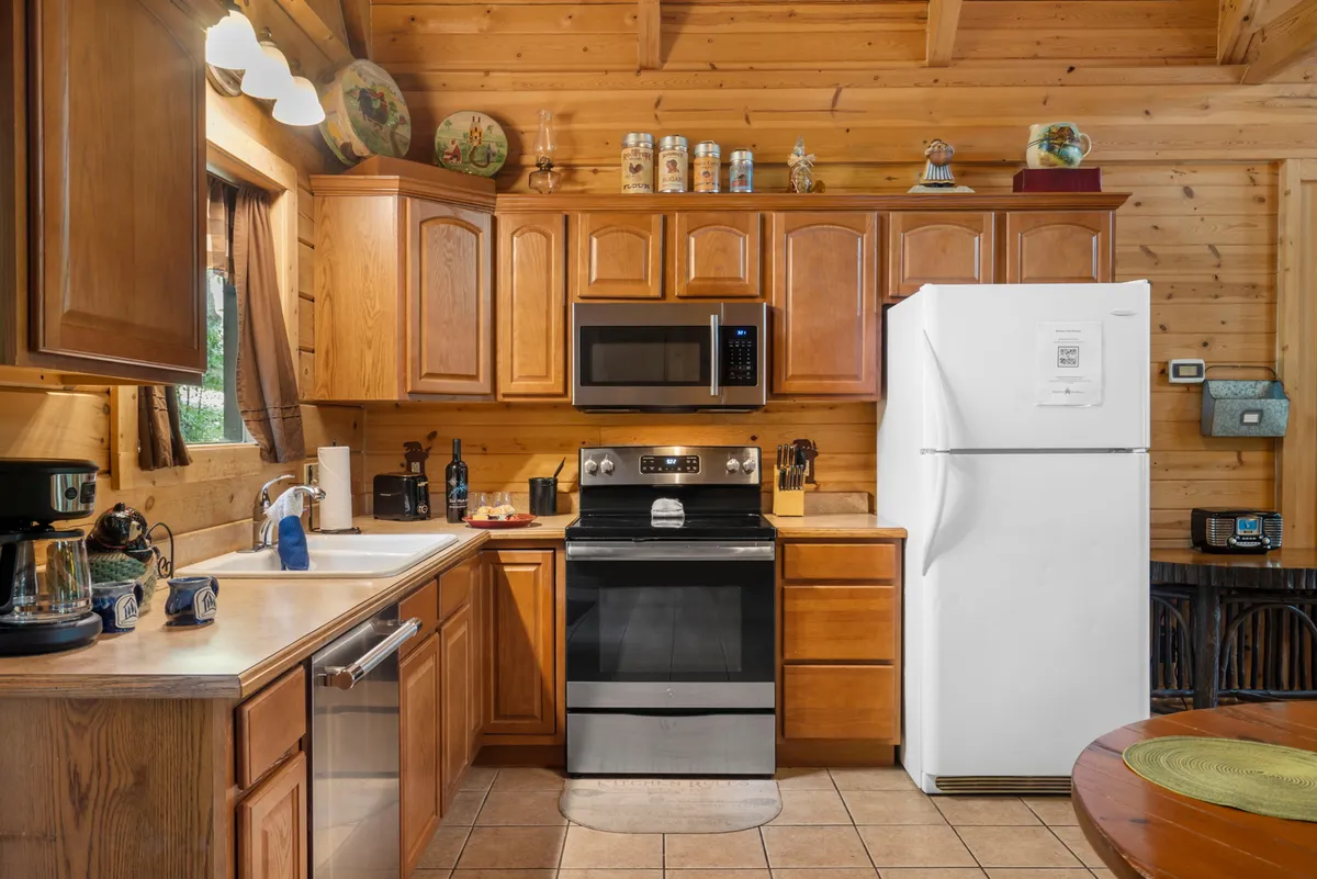 A modern yet warm kitchen with stainless steel appliances, wooden cabinetry, and a central kitchen island. The space is ready for both gourmet cooking and casual breakfasts.